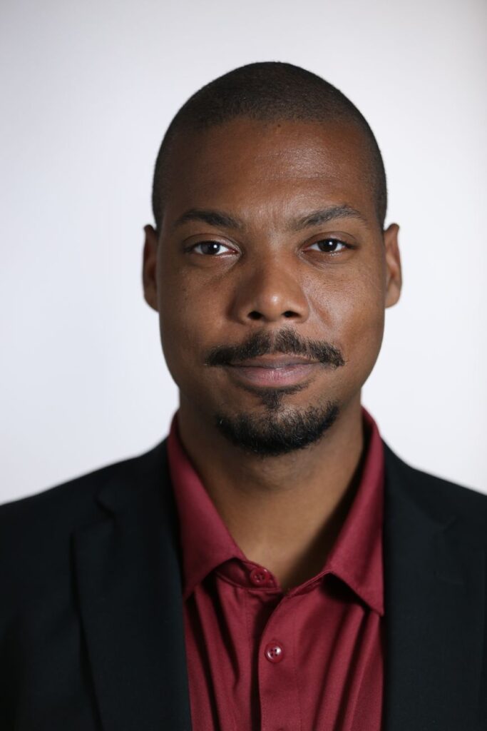Studio portrait of a confident black man in a suit, showcasing focus and determination.