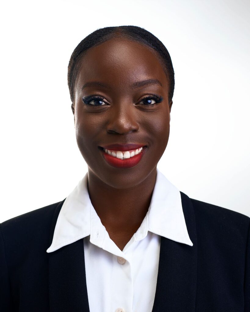 Confident African woman in black suit and white blouse. Ideal for business presentations.